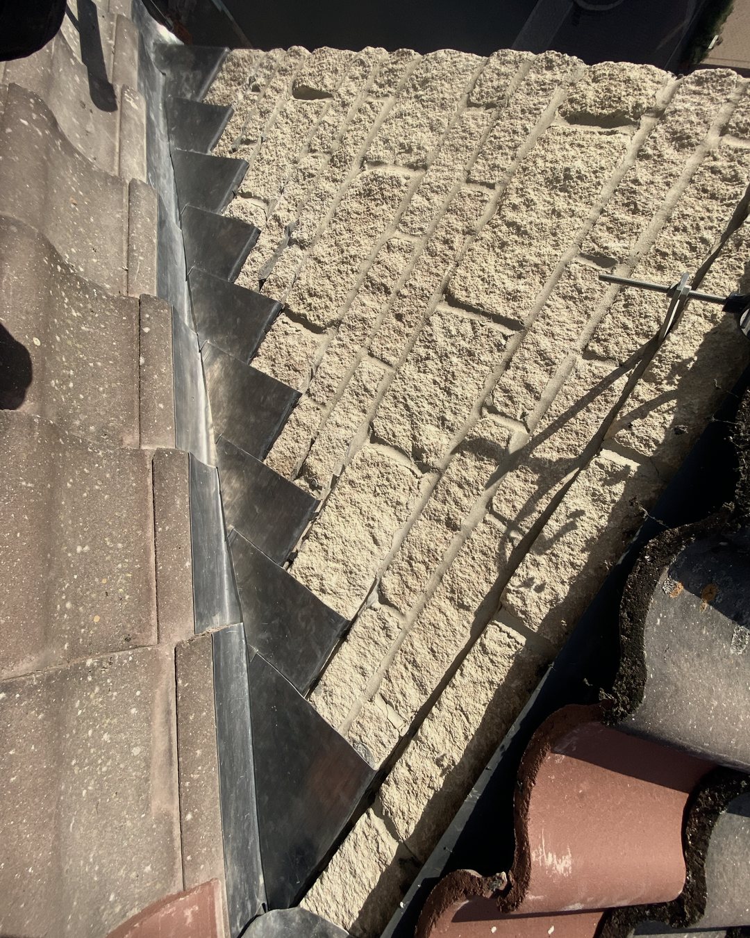 New lead step flashing along a stone wall, seen from above