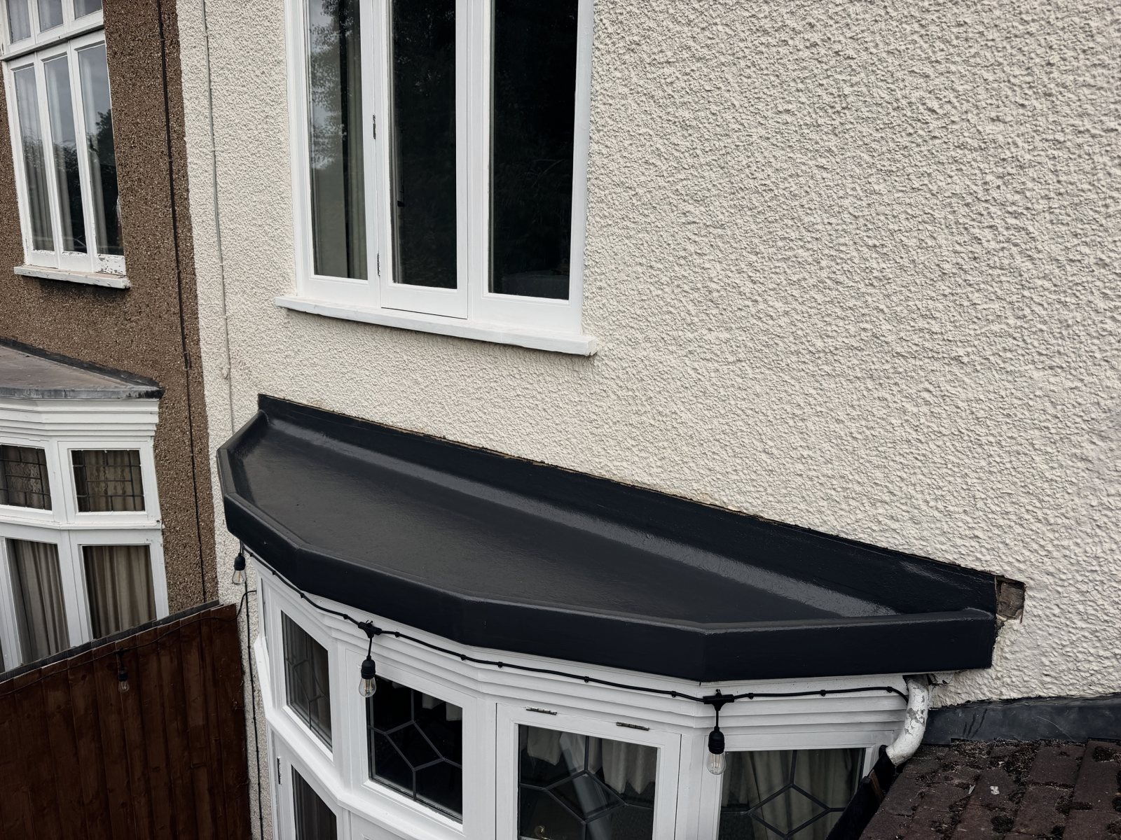 The finished fibreglass roof over the bay, dark grey, seen from the side