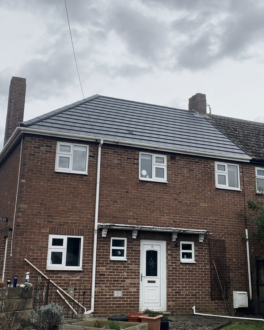 The new grey roof seen from the garden, above the back of the house