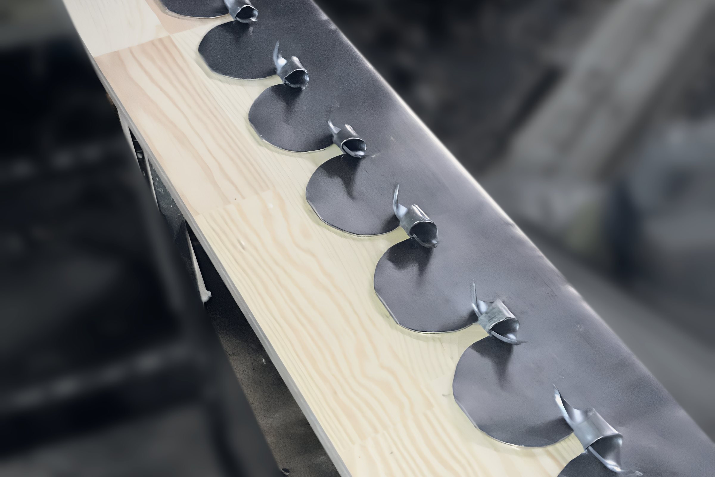 Lead flashing cut and dressed by hand on the bench, with fixing clips along its edge