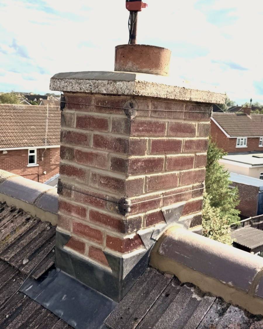 After: the stack repointed, with new lead flashing and the ridge re-bedded