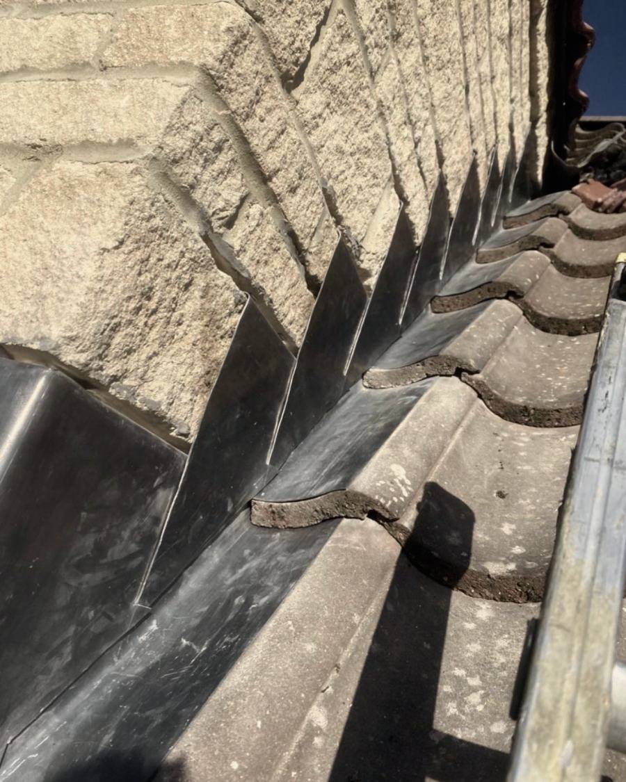 After: new lead step flashing dressed into the stone wall