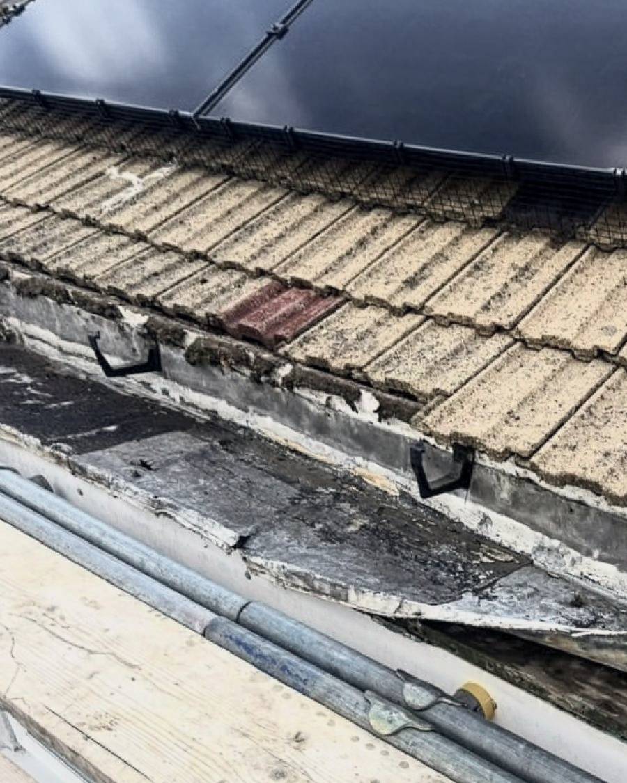 Before: split and perished box gutter lining beneath solar panels